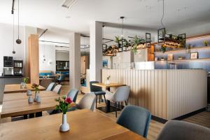 a restaurant with wooden tables and blue chairs at Atrium Hotel Krüger in Rostock