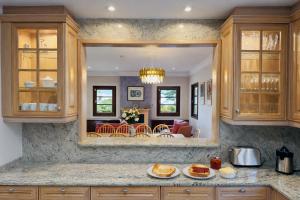 a kitchen with a living room and a dining room at Villa Nobleza, oasis con piscina y gimnasio a 2 min del centro in El Port de la Selva