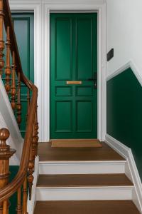 a green door in a hallway with stairs at Greenbrook Homes - Family 7PPL in Aalborg