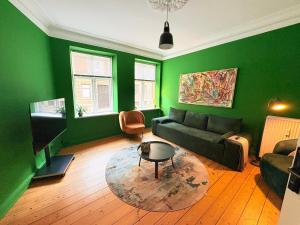 a green living room with a couch and a table at Greenbrook Homes - Family 7PPL in Aalborg