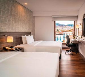 a hotel room with two beds and a window at Hampton By Hilton Cusco in Cusco +84 photos