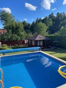 a swimming pool in front of a house at Хлеча house in Stantsiya Korchi