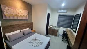 a bedroom with a white bed and a desk at Kasa Boutique Hotel Bacolod in Bacolod