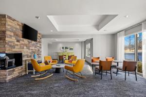 a living room with yellow chairs and a fireplace at Spark by Hilton Macon North in Macon