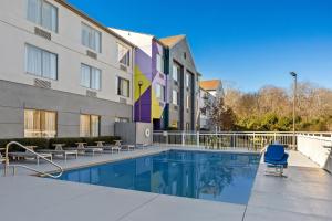 a swimming pool in front of a building at Spark by Hilton Macon North in Macon