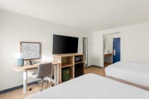 a hotel room with a bed and a desk with a television at Spark by Hilton Matteson Chicago I 57 in Matteson