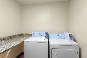 a kitchen with a washer and dryer next to a counter at Spark by Hilton Matteson Chicago I 57 in Matteson