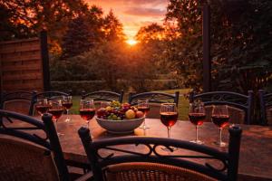 a table with glasses of wine and a bowl of fruit at Großes Ferienhaus Bucheneck für Gruppen, Familien & Firmen 7 Schlafzimmer 3 Bäder große Terrasse nahe Rhododendronpark Kromlau in Kromlau