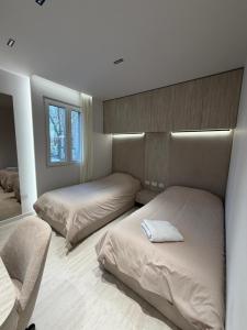 a bedroom with two beds and a chair and a mirror at RETLAV LUXURY Apartment in San Donato Milanese