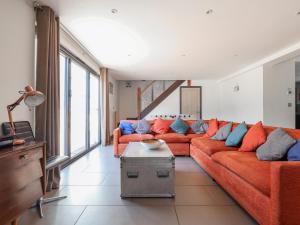 a living room with a orange couch with blue pillows at Rusty Barn in Gloucester