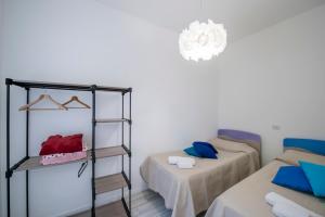 a small room with two beds and a chandelier at VivimiHome - Casa Tiberio in Conca dei Marini