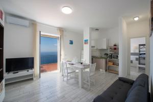 a living room with a couch and a table with a view at VivimiHome - Casa Tiberio in Conca dei Marini