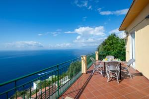a balcony with a table and chairs and the ocean at VivimiHome - Casa Tiberio in Conca dei Marini +9 photos