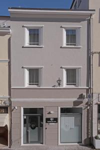 a large white building with windows and a store at Residenza del Centro in Fabriano