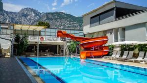 a resort swimming pool with a slide in front of a building at Nex Royal Beach in Antalya