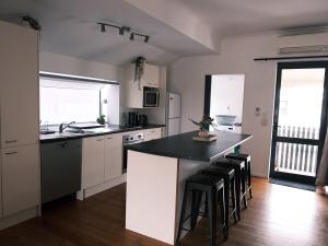 a kitchen with white cabinets and a black counter top at Sweet Home in Avalon in Lower Hutt