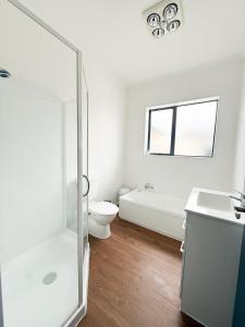 a bathroom with a shower and a toilet and a sink at Sweet Home in Avalon in Lower Hutt +18 photos