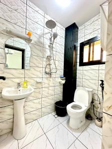 a bathroom with a toilet and a sink at Aud'Meublé Logpom in Douala +11 photos