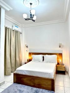 a bedroom with a large bed with white sheets at Aud'Meublé Logpom in Douala