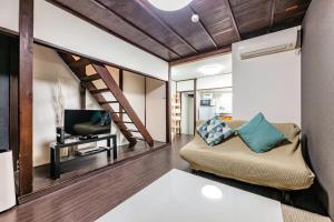 a living room with a couch and a tv at YAGARA TERRACE HOUSE OSAKA Room A in Osaka