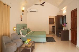 a bedroom with a bed and a couch and a chair at Close2C By The Arks Villa in Anjuna