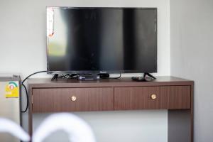 a television sitting on top of a wooden stand at TP Residence เคหะร่มเกล้า in Lat Krabang