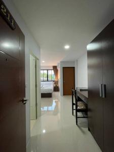 a living room with a table and a room with a bed at TP Residence เคหะร่มเกล้า in Lat Krabang