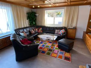 a living room with a black leather couch and a rug at Ferienhaus Holiday in Radstadt