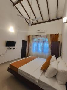 a bedroom with a large bed with a window at Shalom Resort in Avissawella