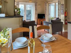 a dining room table with plates and a bottle of wine at Mimosa - Uk51224 in Swyre