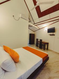 a bedroom with a bed and a tv and a table at Shalom Resort in Avissawella