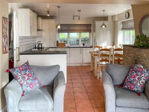 a kitchen and living room with two chairs and a table at Mimosa - Uk51224 in Swyre