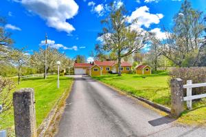 a house on a road with a fence at "Hasselbacken" in Vimmerby