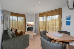 a living room with a couch and a table at Luna Lodge Wānaka - digital check-in only in Wanaka