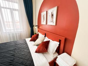 a red room with a bed with pillows on it at Bekarys Hotel in Astana