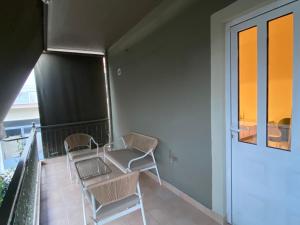 a balcony with chairs and a table and a window at RYB Colour Apartment in Patra