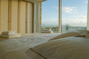 a bedroom with a large bed with a large window at Villa Zeno in Tragána +35 photos