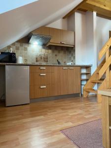 a large kitchen with wooden cabinets and a staircase at Penzión - Tempo in Kremnica