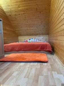 two beds in a wooden room with two rugs at Penzión - Tempo in Kremnica