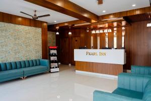 a lobby with blue couches and a sign that reads pearl inn at Pearl Inn in Dhārwād