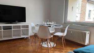 a living room with a table with chairs and a television at Cute apartment in lovely Constance in Konstanz