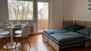 a bedroom with a bed and a table and a table and chairs at Cute apartment in lovely Constance in Konstanz
