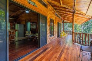 a large wooden porch of a house with a deck at Charming Villa Surrounded by Nature Punta Uva in Puerto Viejo
