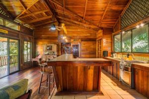 a large kitchen with wooden walls and a large island at Charming Villa Surrounded by Nature Punta Uva in Puerto Viejo +34 photos