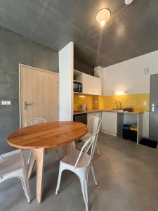 a wooden table and chairs in a kitchen at Résidences EMA-CNIFOP in Saint-Amand-en-Puisaye +6 photos