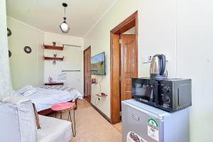 a living room with a tv and a bed at GoldKent Kileleshwa in Gatunga