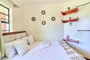 a bedroom with a bed with pillows on it at GoldKent Kileleshwa in Gatunga