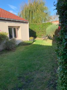 a yard with a small house and a tree at A l'abri des flots in Ambleteuse