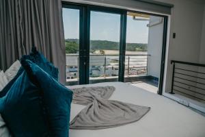 a bedroom with a bed and a large window at Gonubie Beachside Delight Apartment in East London