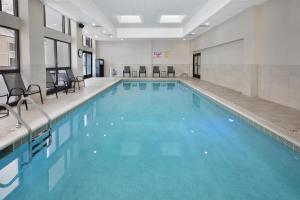 a large swimming pool with blue water in a building at DoubleTree by Hilton Hotel Detroit Novi in Novi